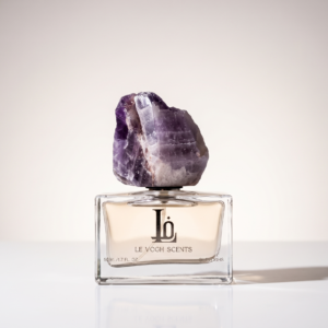 Ghaim Eau de Parfum bottle by Le Vogh with purple gemstone cap and flowers